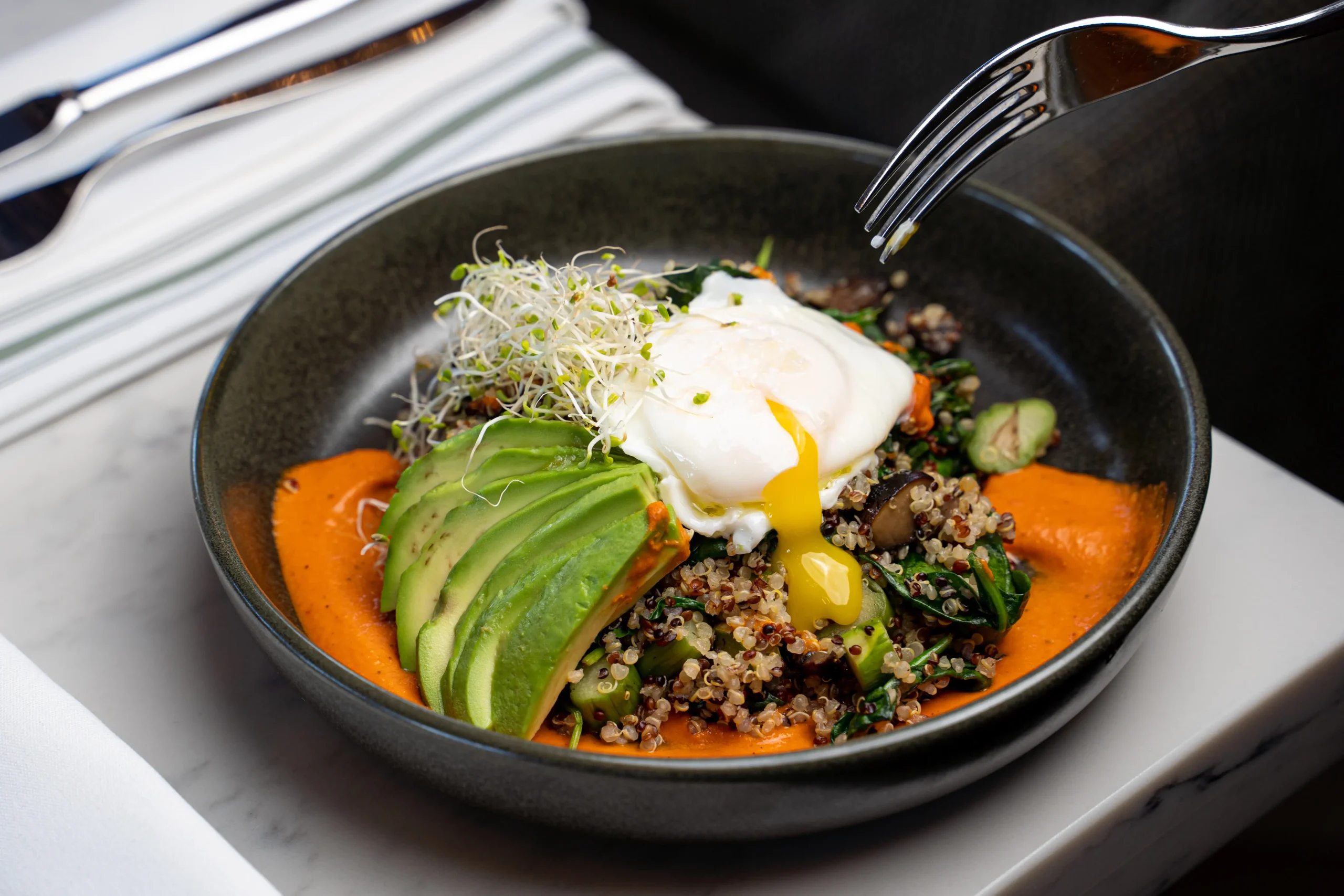 quinoa bowl with avocado slices and poached egg