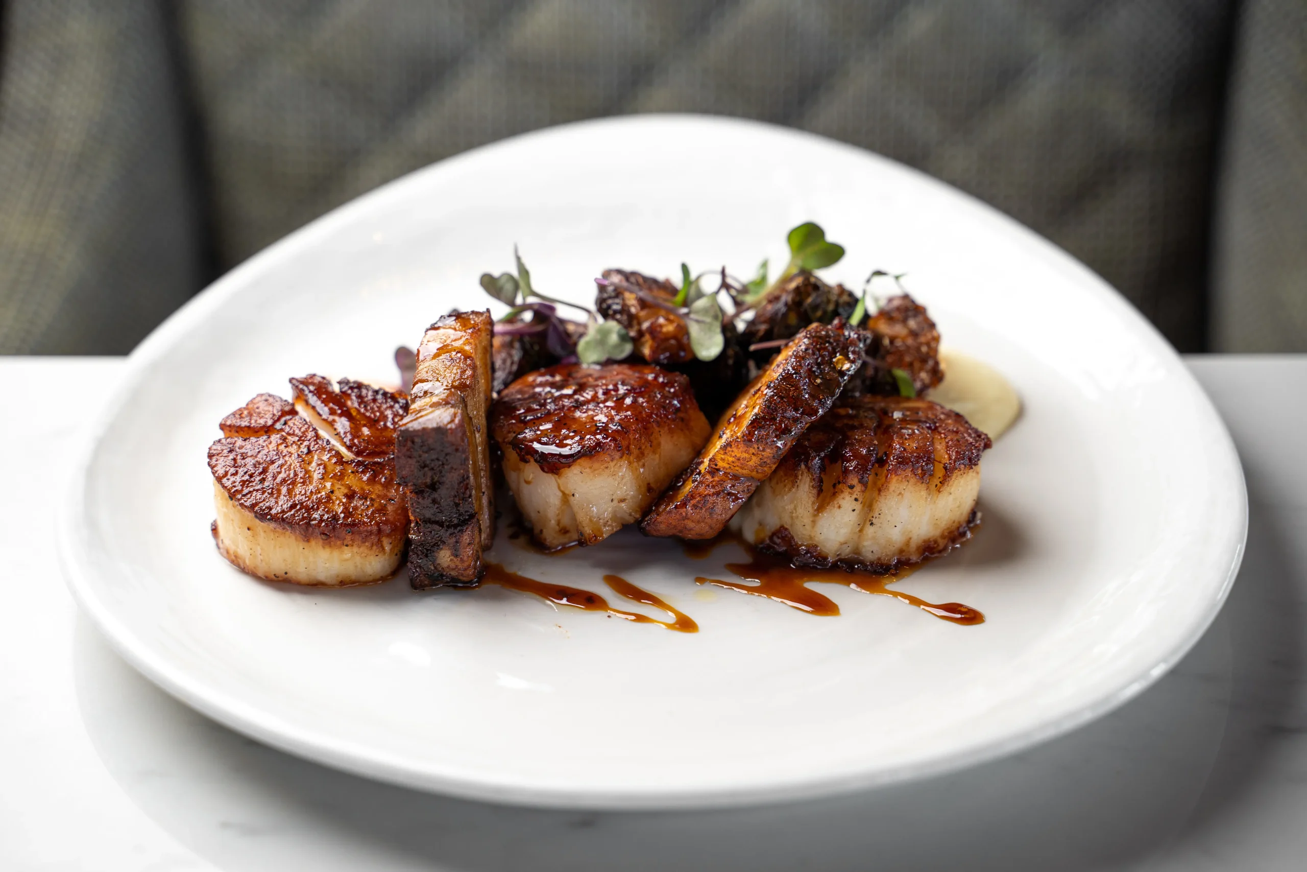 roasted scallops plated on white dish
